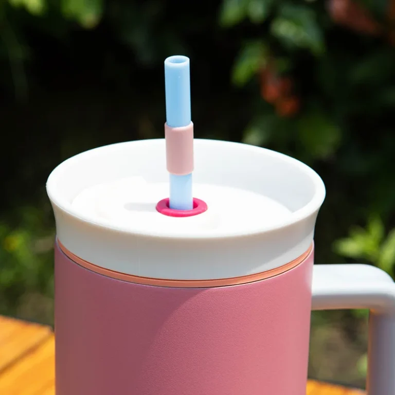 pink custom water bottle with straw and handle on desk