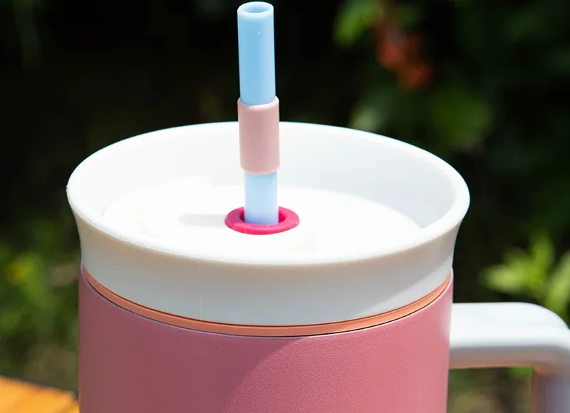 pink custom water bottle with straw and handle on desk